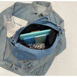 Vue de dessus du grand sac en jean montrant l'intérieur spacieux pour tablettes et accessoires