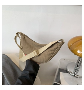 Detail of corduroy dumpling bag featuring adjustable strap and ribbed fabric texture