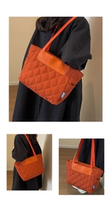 Detailed view of orange quilted tote bag with diamond stitching and brand logo tag