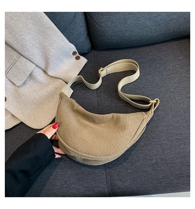 Detailed texture of khaki corduroy crescent bag showing fabric ribs and adjustable strap