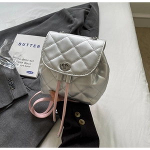 Détail du sac à dos en cuir matelassé argenté avec bandoulière rose et fermoir