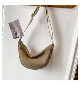 Detailed texture of khaki corduroy croissant bag with adjustable fabric shoulder strap