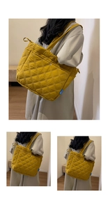 Détail du sac cabas matelassé jaune avec coutures en losanges et étiquette latérale