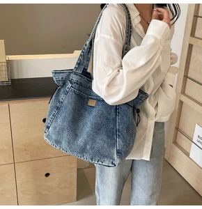 Detail der gewaschenen blauen Denim-Tragetasche mit Lederpatch und Kordelzugverschluss