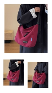 Detail of burgundy tote bag with logo patch and adjustable shoulder strap for travel