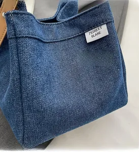 Close-up of blue denim tote bag texture with 7STREET 6LANE label and leather handle