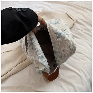 Detail of embroidered butterfly tote bag with magnetic clasp and spacious dark interior