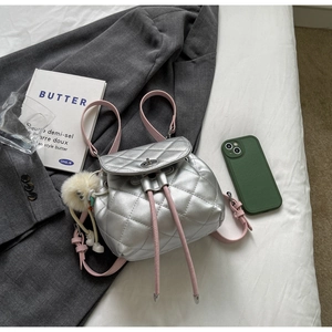 Détail du mini sac à dos en cuir matelassé argenté avec bretelles roses et pompon doux