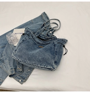 Detail einer gewaschenen blauen Denim-Tragetasche mit Kordelzug und Doppelgriffen