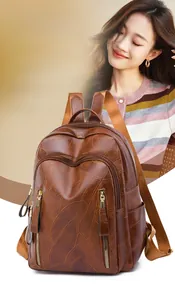 Close-up of deep brown leather backpack featuring leaf vein embossing and gold zippers