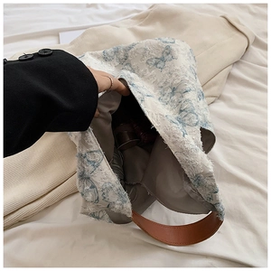 Close-up of embroidered butterfly tote bag featuring spacious interior and brown straps