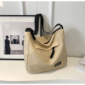 Close-up of beige large capacity tote bag with SHU NUO label and black woven rope