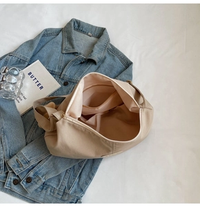 Detail view of large beige hobo bag showing zipper closure and internal pocket lining