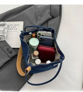 Top view of spacious interior of blue denim tote bag filled with daily essentials