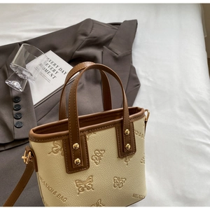 Detail of lychee pattern bucket bag with embossed butterfly and metal rivets
