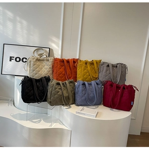 Gros plan de sacs fourre-tout matelassés légers en plusieurs couleurs sur présentoir