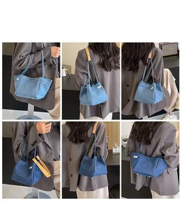Detail view of stylish denim tote bag with leather handles shown in a lifestyle setting