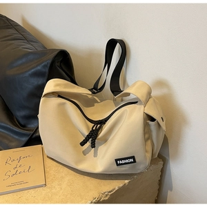 Detail der beige Nylon-Umhängetasche mit schwarzem Gurt und gewebtem Doppelreißverschluss