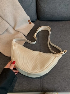 Beige corduroy crescent shoulder bag with adjustable strap and vintage texture design