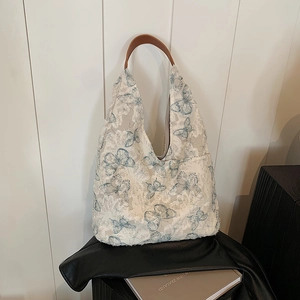 Chic butterfly embroidered tote bag with brown leather handles and frayed edges