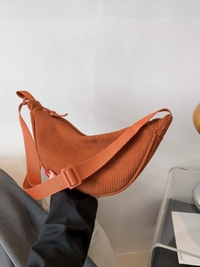 Caramel orange corduroy crescent shoulder bag with adjustable strap in a minimalist style