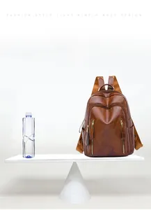 Brown leather backpack weighing 0.45kg compared to a water bottle on scale for lightness