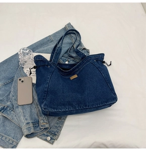 Detailansicht der großen dunkelblauen Denim-Einkaufstasche mit Kordelzug und Lederpatch