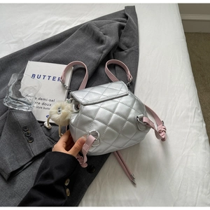 Détail du mini sac à dos argenté matelassé avec bretelles roses et charm peluche