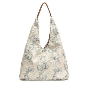 Retro embroidered tote bag with light blue butterfly pattern and frayed texture detail