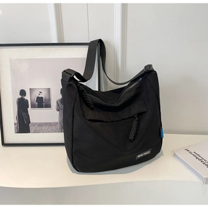Detail view of large capacity black nylon hobo bag with adjustable strap and front pocket