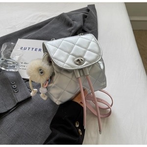 Détail du sac à dos argenté matelassé avec cordon rose et pompon en peluche doux