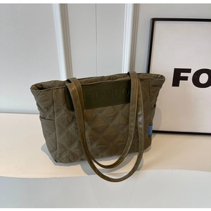 Close-up of olive green quilted tote bag featuring diamond stitching and logo detail