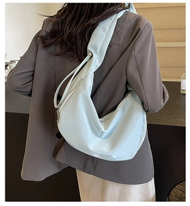 Detail of light blue crescent hobo bag made of semi-matte synthetic leather with strap