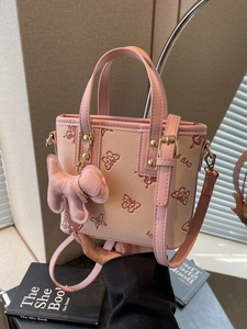 Pink lychee texture bucket bag with butterfly embossing and dog charm for women