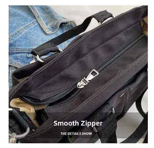 Close-up of smooth silver zipper and durable black canvas strap on a tote bag