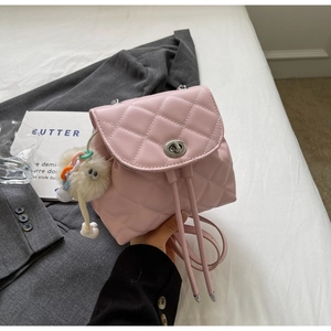 Détail du mini sac à dos rose matelassé avec cordon de serrage et breloque en peluche