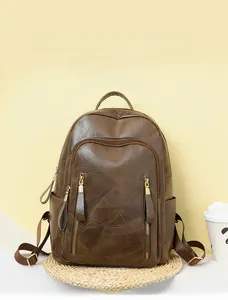 Detail of dark brown retro PU leather backpack with textured finish and dual front zippers