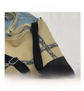 Detail of khaki canvas tote with geometric woven strap and adjustable metal buckle