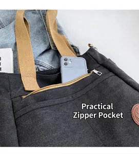 Détail du cabas en toile noire avec une poche avant zippée pratique pour le téléphone