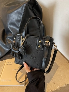 Black pebbled leather bucket bag with butterfly embossing and dog charm detail