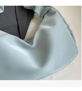 Close-up of light blue pleated dumpling bag showing soft synthetic leather texture