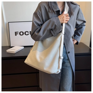 Detail of minimalist cream canvas tote bag with wide cotton shoulder strap for daily use