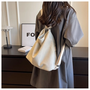 Detailed back view of a white canvas backpack on a model in a minimalist modern setting