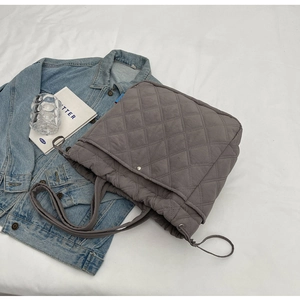 Détail du sac cabas matelassé gris avec motif à losanges et cordon de serrage