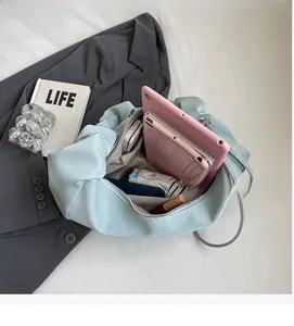 Detailed interior of light blue pleated hobo bag showing spacious pockets and storage