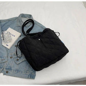 Détail du sac cabas matelassé noir avec boucle en métal argenté et cordon de serrage