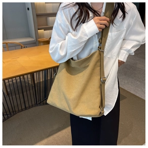 Detailed view of khaki canvas tote bag featuring adjustable shoulder strap and large capacity