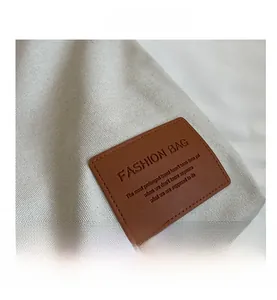 Macro view of textured canvas bag with premium brown embossed leather patch detail