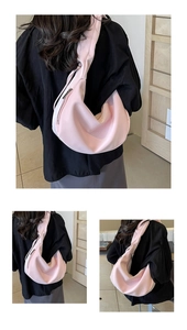 Macro detail of the smooth pink crescent crossbody bag with silver zipper and wide strap