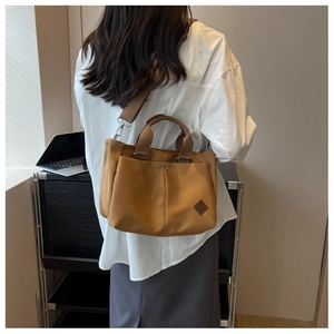 Detail view of khaki canvas tote bag with wide shoulder strap and dual top handles